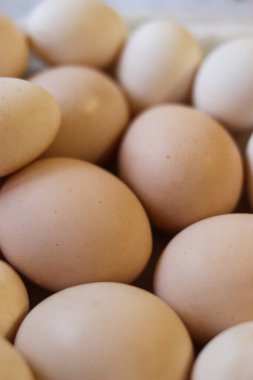 Doğal ışık altında taze kahverengi yumurtaların yakın görüntüsü. Organik tarım ürünü, basit kompozisyon, yumuşak odaklanma. Gıda ve pazar kavramları için doğal doku ve nötr tonlar. Yüksek kalite fotoğraf