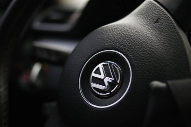 Uzhhorod, Ukrayna -5 Nisan 2025. Modern bir arabanın içindeki siyah deri direksiyonlu bir Volkswagen logosu, otomotiv markasını ve iç tasarımı vurguluyor. Yüksek kalite fotoğraf
