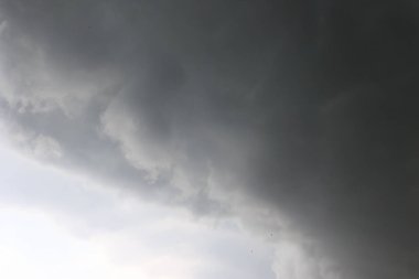 Fırtınadan önce gökyüzünde kara fırtına bulutları oluşuyor. Dramatik, dengesiz atmosfer tehlikeyi, doğal gücü ya da duygusal gerilimi simgeliyor. Yüksek kalite fotoğraf