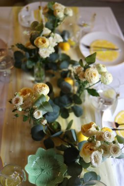 Beyaz, sarı güller ve yeşil okaliptüs yapraklı limon masa süsü. Taze ve zarif, düğünler için mükemmel, yaz yemekleri, ya da kırsal temalı etkinlikler. Yüksek kaliteli fotoğraf.