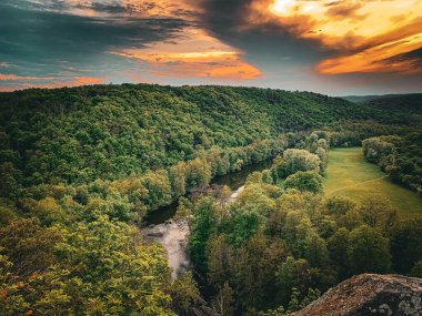 Nehir ve ormanlı güzel bir manzara.