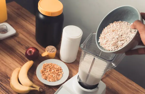 Pov, yulaf ezmesi, muz ve fıstık ile protein karışımı hazırlıyor..