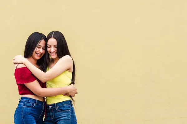 Sarı Duvarda Sarılan Iki Genç Latin Amerikalı Arkadaş Mutluluk Arkadaşlık — Stok fotoğraf