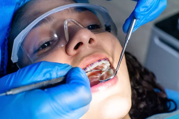 Diş hekimi parantez içinde sözlü muayene yapıyor..