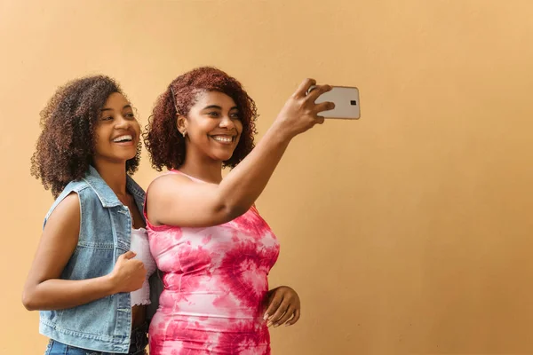two young smiling black woman taking a selfie, dental health concept.