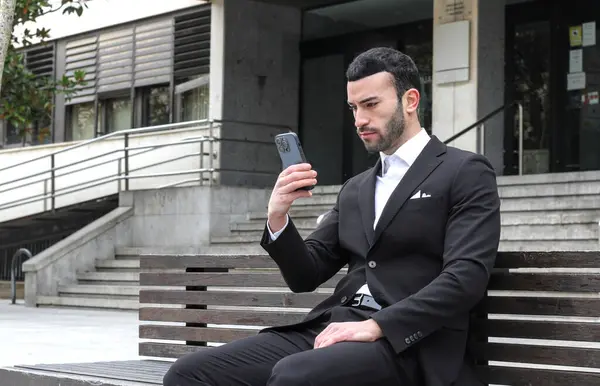 Man in suit on a cell phone video call in the street