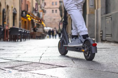 Elektrikli scooter, dikiz aynası, araba, tanınmaz halde, sokakta, sıradan bir elbise.