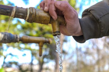 Beyaz el sıkma havuzu, düşen su, odaklanmamış park arka planı, arka musluk. Su kavramı