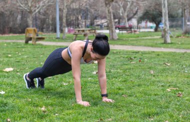 Açık havada şınav çeken güzel beyaz bir kadın, spor elbisesi, gülümseme, fotokopi odası. Spor anlayışı