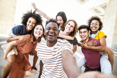 Happy young people smiling together looking at camera. Youth lifestyle concept with teens hanging out clipart