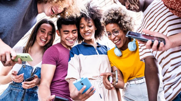 大学のキャンパスで携帯電話を見ている幸せな大学生 ソーシャルメディア技術に依存している10代の若者は — ストック写真