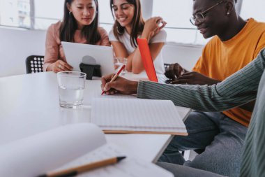 Okul ödevi için kütüphanede çalışan çok ırklı gençler. Eğitim ve gençlik kültürü kavramı