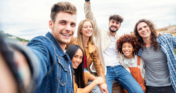 Группа молодых людей улыбается вместе перед камерой. Студенты университета веселятся в студенческом городке. Концепция дружбы