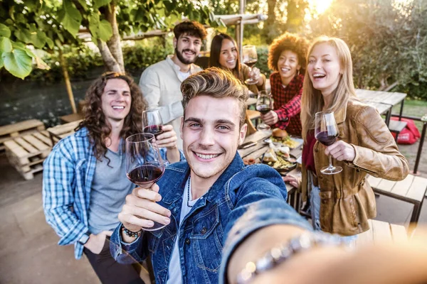 一緒に赤ワインを飲む若い人たち 外で食事をする男と女の子との友情の概念 明るいフィルター — ストック写真
