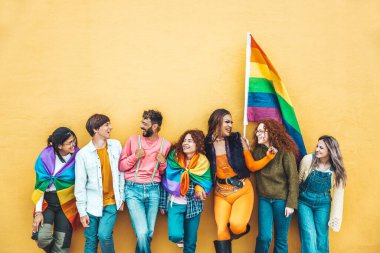 Lgbt topluluğunun konsepti, erkek ve kızların açık havada kucaklaşması, sarı arka planda duran çok ırklı trend arkadaşları,
