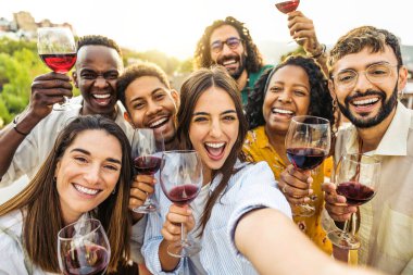 Bir grup genç kız ve erkeklerin yaz tatilinin tadını çıkardıkları açık havada selfie çekiyorlar.