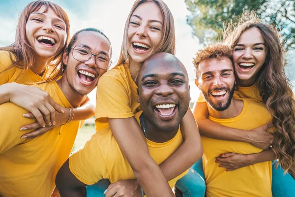 大学のキャンパスで一緒に楽しい学生 外に立って黄色のTシャツを着て多文化の友人のグループ — ストック写真