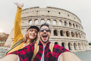 İtalya, Roma 'da Colosseum' u ziyaret eden mutlu bir çift. Genç Arkadaşlar, Avrupa 'yı ziyaret eden Guy ve Kız Kolezyum' da akıllı telefonlarıyla selfie çekiyor. Seyahat etkisindeki teknoloji ve aşk konsepti.
