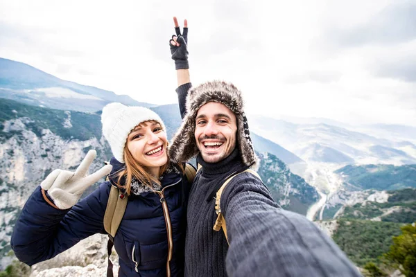 Sırt çantalı gezgin çift selfie çekiyorlar dağ yürüyüşü yapıyorlar mutlu adam ve kız dışarıda eğleniyorlar aşk ve seyahat konsepti