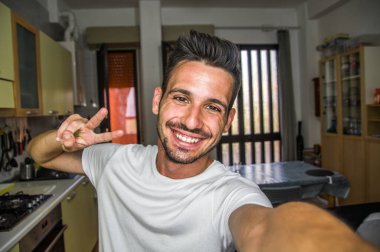 Yakışıklı beyaz bir adam evde fotoğraf çekiyor - kameraya gülümseyen mutlu bir adam - yüksek kalite fotoğraf