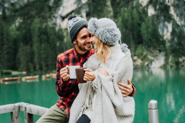 Braies, İtalya 'da bir dağ gölünü ziyaret eden genç ve güzel bir çift - sonbahar yaprakları arasında tatil yapan yürüyüş kıyafetli turistler - seyahat, yaşam tarzı ve seyahat tutkusu kavramları