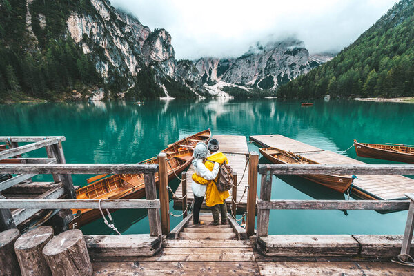 Hikers visiting italian alpine Braies Lake - Couple in love enjoying stunning view of Lago di Braies in Dolomites, South Tyrol, Italy, Europe.