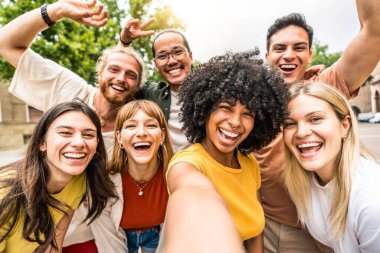 Dışarıda kameraya gülümseyen çok kültürlü arkadaşlar - akıllı cep telefonu cihazıyla selfie çeken mutlu gençler - gençlik toplumu ve teknoloji kavramı