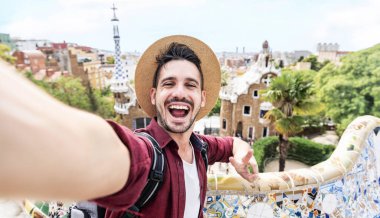 Mutlu turistler akıllı telefonlu selfie çekerler Park Guell, Barcelona, İspanya 'da - Gülümseyen adam kameraya bakıyor - tatiller ve seyahat konsepti