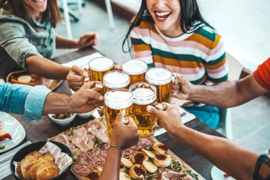 Bira barında bira içen bir grup insan, bar masasında oturup eğlenen mutlu arkadaşlar, bira bardaklarının yakın plan görüntüsü, yiyecek ve içecek yaşam tarzı konsepti.