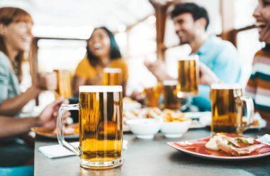 Birahane bar restoranında bira içen mutlu insanlar, bar masasında oturup eğlenen bir grup arkadaş, bira fabrikası yaşam tarzı konsepti, kızlar ve erkekler birlikte yemek yiyor.