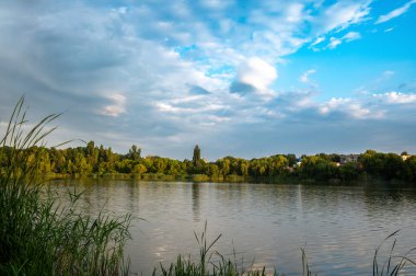 Gün batımında göl. Akşam güneşi suda parlıyor..