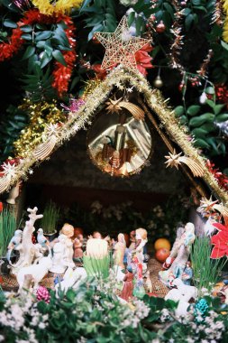 Çiçeklerle çevrili bir ahır sahnesinin Noel sahnesi