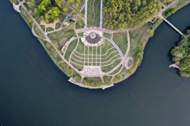 Overlooking a unique spiral landmark and bustling riverfront, this drone image invites viewers to explore the heart of Minsk, where urban design meets natural beauty.