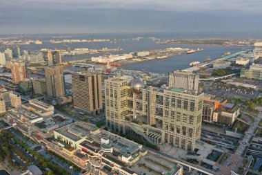 The warm glow of the golden hour bathes Tokyo Bay and the city's modern architecture in a serene light, captured from the air.