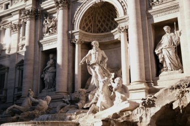 Rome's iconic Trevi Fountain, basked in sunlight, displays the intricate details of its marble sculptures, alive with flowing water.