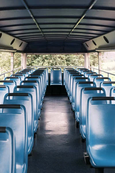 The empty upper deck of a sightseeing bus in Brazil awaits its passengers, with rows of blue seats offering a promising view for future tours. The image conveys a sense of anticipation and the quiet before the bustle of tourists seeking to explore th