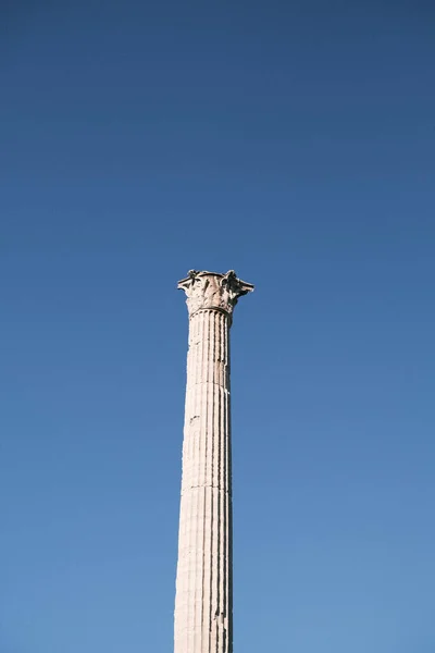 Standing tall against the crisp blue sky of Rome, a solitary Corinthian column remains a proud vestige of the architectural magnificence that once graced the city\'s skyline, a column that has borne witness to history.