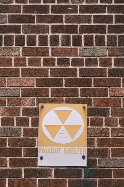 A stark reminder of past tensions, this Fallout Shelter sign affixed to a brick wall in New York stands as a historical artifact and a symbol of the Cold War era.