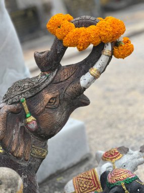 A traditional Thai elephant statue adorned with vibrant garlands captures the artistic essence and spirituality of Patong.