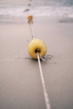 The simple yet captivating view of a buoy rope leading into the calm sea at Patong Beach, Thailand, invites serene contemplation.