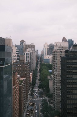 This aerial perspective captures a New York City street, flanked by buildings, creating an 'urban canyon' that showcases the city's verticality and density.