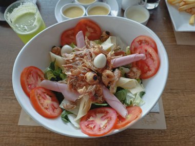 Izgara tavuk, jambon, peynir, mantar ve bıldırcın yumurtalarıyla süslenmiş taze salata.