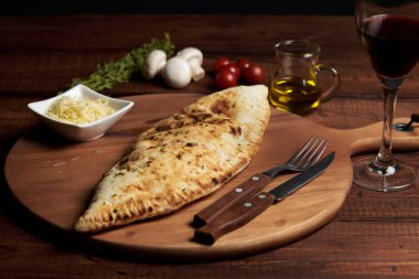 Calzone, geleneksel İtalyan hazırlıklarına baharatlar ve kırmızı şarap eşlik eder.