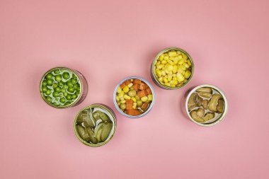 Çok renkli konserve sebzeler, zenital veya üst çekim pembe arkaplan ve metin için boşluk