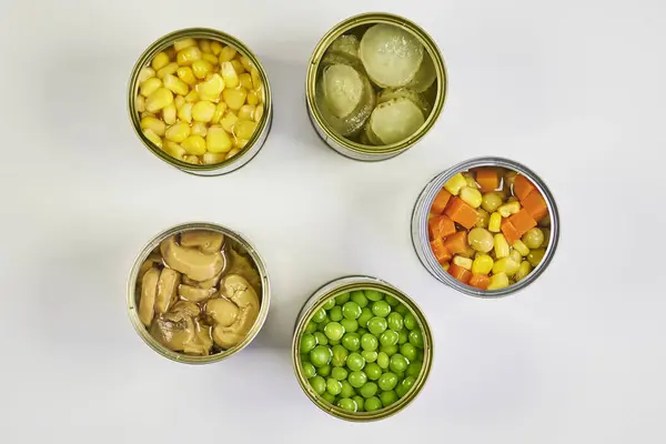 Çok renkli konserve sebzeler, zenital veya üst çekim beyaz arkaplan ve metin için boşluk