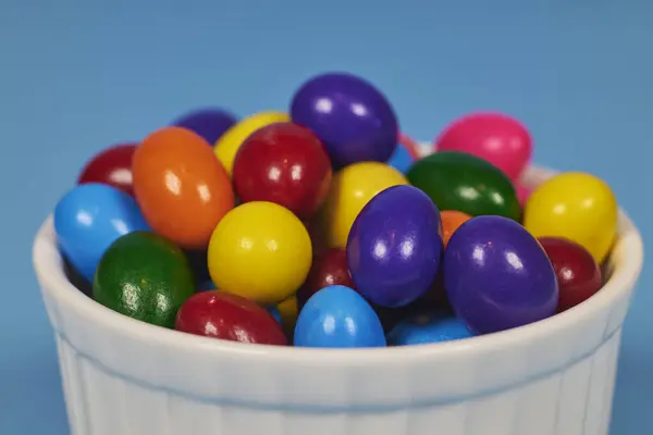 Metin yerleştirmek için homojen arkaplan içeren parlak toprak kaplarında farklı renkte sakız topları çiğnemek