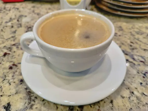 Izgara yumurta ve jambonlu lezzetli geleneksel kahvaltı yanında da dumanı üstünde lezzetli bir kahve.