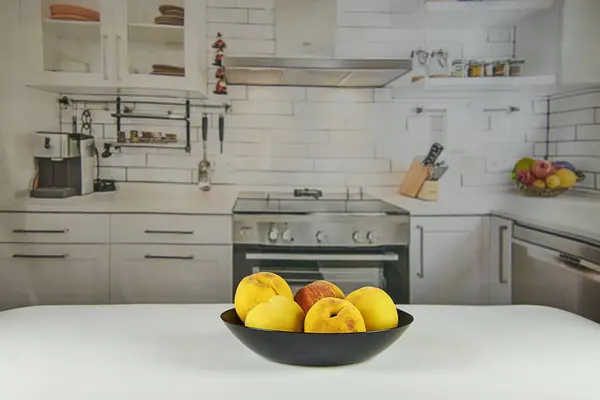 Şeftaliler siyah bir tabakta, ahşap bir masada, kırsal bir mutfakta..