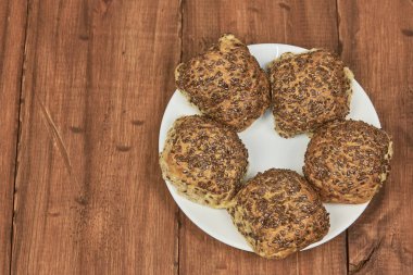 Tam tahıl konsepti. Keten tohumlarıyla süslenmiş ev yapımı tam buğday ekmeği, yakın plan fotoğraf.