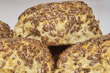 Tam tahıl konsepti. Keten tohumlarıyla süslenmiş ev yapımı tam buğday ekmeği, yakın plan fotoğraf.